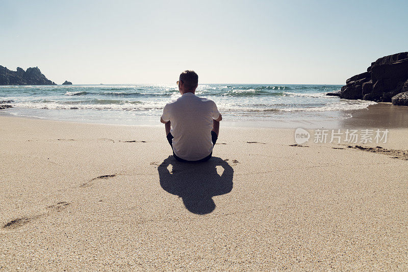 康沃尔，一名男子坐在Pedn Vounder海滩上，享受着孤独和阳光